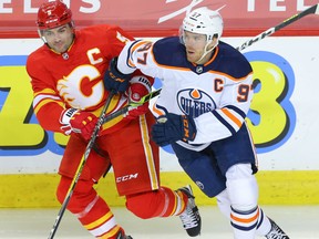 Calgary Flames captain Mark Giordano battles against Connor McDavid of the Edmonton Oilers in Calgary on Friday, Feb. 19, 2021.