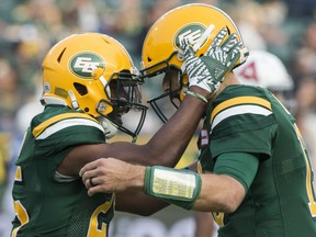 Edmonton Football Team running back Shaquille Cooper (25) celebrates his touchdown against the Montreal Alouettes with quarterback Mike Reilly (13) in this file photo from August 18, 2018, in Edmonton.