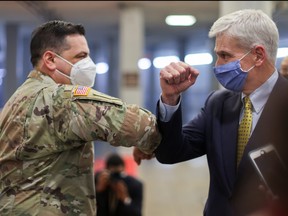 New York U.S. Army National Guard member Vincent Scalise, on duty as security at the U.S. Capitol, elbow bumps U.S. Senator Bill Cassidy (R-LA) in the U.S. Senate subway as Cassidy heads to the Senate Chamber to attend the fourth day of the impeachment trial of former president Donald Trump in Washington, D.C., Feb. 12, 2021.