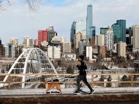 A jogger and their dog enjoy the warm weather along Saskatchewan Drive, in Edmonton Monday Feb. 22, 2021.