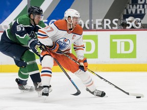 Vancouver Canucks defenseman Tyler Myers (57) checks Edmonton Oilers forward Connor McDavid (97) in the first period at Rogers Arena on Feb. 25, 2021.