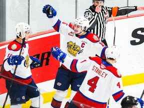 Dylan Guenther (11) of the Edmonton Oil Kings celebrates with teammates Scott Atkinson (15) and Ross Stanley (4) after scoring against the Calgary Hitmen at 7 Chiefs Sportsplex on March 27, 2021, on Tsuut’ina Nation.