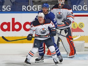 Tyson Barrie (22) of the Edmonton Oilers covers Auston Matthews (34) of the Toronto Maple Leafs at Scotiabank Arena on March 27, 2021, in Toronto. The Maple Leafs defeated the Oilers 4-3 in overtime.