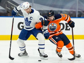 Edmonton Oilers forward Kailer Yamamoto (56) battles Toronto Maple Leafs forward John Tavares (91) during first period NHL action at Rogers Place in Edmonton, on Monday, March 1, 2021.