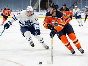 Edmonton Oilers captain Connor McDavid (97) is chased by the Toronto Maple Leafs’ Ilya Mikheyev (65) at Rogers Place in Edmonton on Wednesday, March 3, 2021.