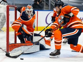 Edmonton Oilers goaltender Mike Smith (41) defends his crease with Adam Larsson (6) without a stick as he battles the Ottawa Senators during second period NHL action at Rogers Place in Edmonton, on Friday, March 12, 2021.