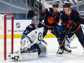 Edmonton Oilers star Connor McDavid scores a goal on Winnipeg Jets goalie Connor Hellebuyck during NHL action at Rogers Place in Edmonton on March 20, 2021.