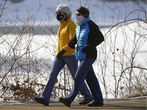 Two women take a brisk stroll on River Valley Road in Edmonton on March 4, 2021.