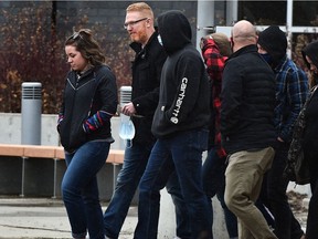 Pastor James Coates, carrying a mask in his hands, walks out of the Edmonton Remand Centre with a group of supporters after being released from the facility late Monday, March 22, 2021.