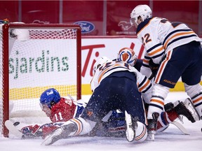 Montreal Canadiens right wing Brendan Gallagher (11) crashes into the net after diving across Edmonton Oilers goaltender Mikko Koskinen (19) to score the Canadiens third goal during NHL action in Montreal on Tuesday, March 30, 2021.
