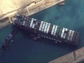 This satellite imagery released by Maxar Technologies shows tug boats and dredgers attempting to free the MV Ever Given on March 26, 2021, in the Suez Canal.