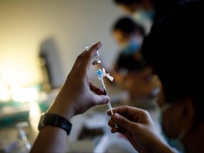 Nurse Kevin Sagun with Humber River Hospital draws a dose of the Moderna COVID-19 vaccine before administering it at a LOFT community housing complex in Toronto, March 26, 2021.