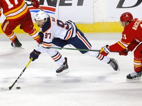 Calgary Flames Mikael Backlund battles Edmonton Oilers Connor McDavid in third period NHL action at the Scotiabank Saddledome in Calgary on Monday, March 15, 2021.