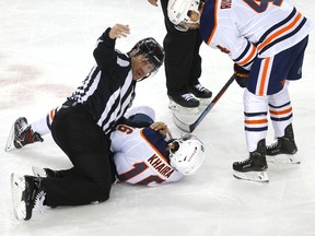 Edmonton Oilers' Jujhar Khaira, right, takes a punch on the chin