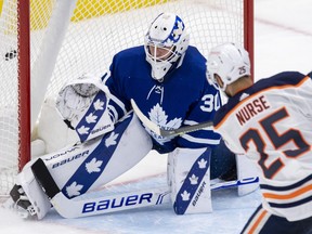 Edmonton Oilers defenceman Darnell Nurse (25) scores the game winning goal on Toronto Maple Leafs goaltender Michael Hutchinson (30) during overtime NHL action in Toronto on Monday March 29, 2021.