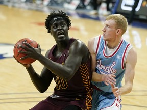 Loyola University Chicago forward Aher Uguak (30) drives to the basket past Drake University guard Garrett Sturtz during the first half of an NCAA college basketball game on Feb. 13, 2021, in Des Moines, Iowa.