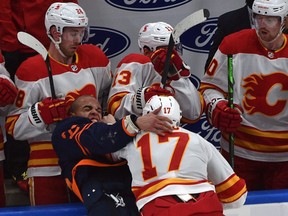 Edmonton Oilers' Darnell Nurse (25) and Calgary Flames' Milan Lucic (17) fight along the Flames bench during NHL action at Rogers Place in Edmonton, March 6, 2021.