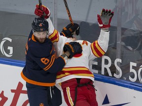Edmonton Oilers' Adam Larsson (6) holds Calgary Flames' Mikael Backlund (11) on Feb. 20, 2021, in Edmonton.
