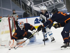 Edmonton Oilers goalie Mikko Koskinen (19) makes a save on the Winnipeg Jets' Josh Morrissey (44) with some help from Adam Larsson (6) on Thursday, March 18, 2021, in Edmonton.