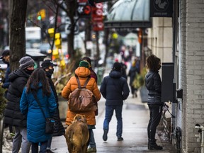 People wait to ordering takeout outside a coffee shop along Queen St. W. near Trinity Bellwoods Park in Toronto, Ont. on Sunday Feb. 28, 2021.