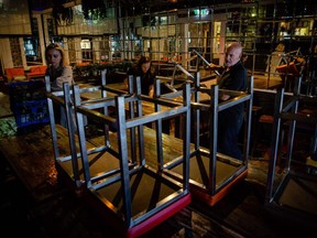 Family hotel owners Katherine, Rebecca and Les Pullos, left to right, stack bar stools in their family bar in Brisbane on March 29, 2021, as more than two million people in the city entered a three-day lockdown after a cluster of coronavirus cases was detected in Australia's third-largest city.
