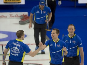 Alberta skip Brendan Bottcher celebrates with second Brad Thiessen (left) and lead Karrick Martin, with third Darren Moulding in the background, after defeating Wild Card 3 during the Tim Hortons Brier at the Markin MacPhail Centre in Calgary on Monday, March 8, 2021.