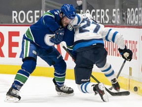 J.T. Miller (9) of the Vancouver Canucks battles with Nikolaj Ehlers (27) of the Winnipeg Jets for control of the puck at Rogers Arena in Vancouver on March 22, 2021.