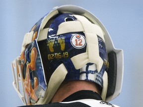 A No. 12 sticker is visible on Edmonton Oilers goaltender Mikko Koskinen's helmet in honour of the late Colby Cave during a training-camp scrimmage, in Edmonton on July 22, 2020.