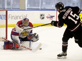 Edmonton Oil Kings goaltender Sebastian Cossa (33) makes a save against the Red Deer Rebels' Josh Medernach (15) in Edmonton on April 3, 2021. The Oil Kings were upset 4-2 by the Rebels in Red Deer on Saturday.