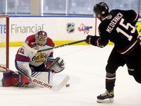 Edmonton Oil Kings goaltender Sebastian Cossa (33) makes a save against the Red Deer Rebels' Josh Medernach (15) during first period WHL action, in Edmonton Saturday April 3, 2021.