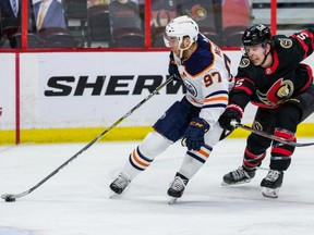 Ottawa Senators defenseman Mike Reilly (5) attempts to check Edmonton Oilers center Connor McDavid (97) during second period NHL action at the Canadian Tire Centre in Ottawa on April 7, 2021.