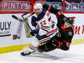 Ottawa Senators left wing Alex Formenton (59) and Edmonton Oilers defenceman Tyson Barrie (22) tie up at the Canadian Tire Centre on Thursday, April 8, 2021.