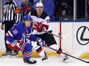 New Jersey Devils defenseman Dmitry Kulikov (70) shoots the puck away from New York Rangers center Ryan Strome (16) during the first period at Madison Square Garden on Jan. 19, 2021.