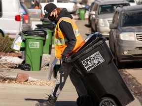 New waste and organics carts are delivered by a city employee in a south Edmonton neighbourhood on March 15, 2021.