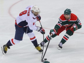 Washington Capitals left wing Alex Ovechkin (8) shoots the puck while being defended by New Jersey Devils defenseman Dmitry Kulikov (70) during the first period at Prudential Center on April 2, 2021.