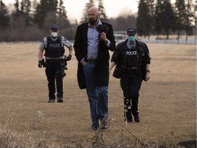 Police escort a man that was sending live video of a fence going up around GraceLife Church on Wednesday, April 7, 2021.