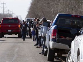 People watch from the road as a fence goes up around GraceLife Church on Wednesday, April 7, 2021. Security is on scene to keep church members away.