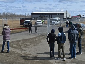 Supporters are seen outside the property of GraceLife Church in Parkland County on Thursday, April 8, 2021, after officials fenced off the church on Wednesday.