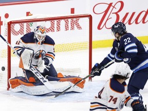 Edmonton Oilers goaltender Mike Smith (41) blocks a shot by Winnipeg Jets center Mason Appleton (22) in the third period at Bell MTS Place in Winnipeg on April 26, 2021.