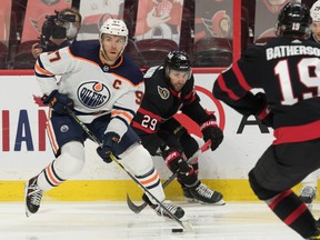 Edmonton Oilers centre Connor McDavid (97) carries the puck ahead of Ottawa Senators centre Michael Amadio (29) at the Canadian Tire Centre on Thursday, April 8, 2021.