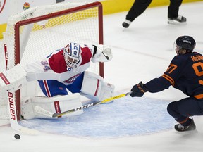 Edmonton Oilers captain Connor McDavid (97) reaches for the puck in front of Montreal Canadiens goalie Jake Allen (34) on Monday, April 19, 2021, in Edmonton.