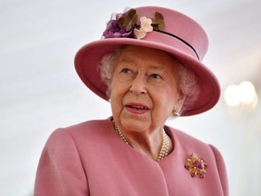 Britain's Queen Elizabeth speaks with staff during a visit to the Defence Science and Technology Laboratory at Porton Science Park near Salisbury, England, Oct. 15, 2020.