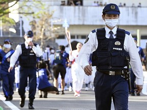 Police officers walk during the Tokyo 2020 Olympic torch relay amid the coronavirus disease (COVID-19) outbreak in Seiyo, Ehime Prefecture, Japan, April 22, 2021.