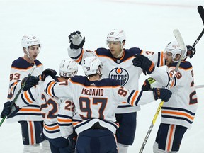 Edmonton Oilers forward Alex Chiasson (top) and the rest of the power-play unit celebrate a goal from Tyson Barrie in Winnipeg on April 27, 2021.