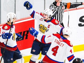 Dylan Guenther #11 (L) of the Edmonton Oil Kings celebrates with his teammates Scott Atkinson #15 (C) and Ross Stanley #4 (R) after scoring against the Calgary Hitmen during a WHL game at Seven Chiefs Sportsplex on March 27, 2021, in Calgary.