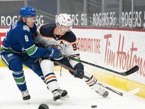 Brock Boeser (No. 6) of the Vancouver Canucks attempts to check Ryan Nugent-Hopkins (No. 93) of the Edmonton Oilers away from the puck during the first period at Rogers Arena on May 3, 2021 in Vancouver.