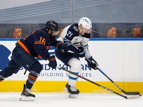 Jujhar Khaira #16 of the Edmonton Oilers battles against Dominic Toninato #21 of the Winnipeg Jets during Game One of the First Round of the 2021 Stanley Cup Playoffs at Rogers Place on May 19, 2021 in Edmonton.