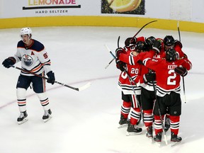 Connor Murphy (5) of the Chicago Blackhawks is congratulated by his teammates after scoring a go-ahead goal in front of Ryan Nugent-Hopkins (93) of the Edmonton Oilers in Game 3 of the Western Conference qualification round prior to the 2020 NHL Stanley Cup Playoffs at Rogers Place on August 05, 2020, in Edmonton. (Photo by Jeff Vinnick/Getty Images)