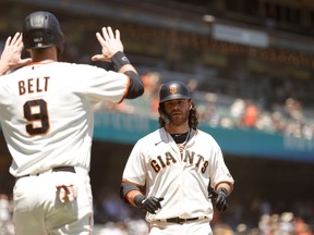Brandon Crawford of the San Francisco Giants is congratulated by Brandon Belt after he hit a three-run home run in the second inning against the San Diego Padres at Oracle Park on May 08, 2021 in San Francisco.