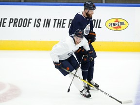 Edmonton Oilers Connor McDavid (97) and Adam Larsson (6) laugh as they take part in the last team practice of the regular season at Rogers Place in Edmonton on Friday, May 14, 2021.